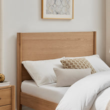 Wooden bedframe headboard and side rails with slatted base; pillows on top
