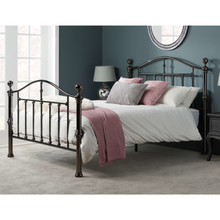Black nickel bedstead with curved headboard, finials, and vertical bar rails