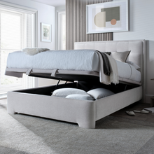 Upholstered ottoman storage bed in light gray with lift-up top open to reveal storage compartment