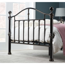Black nickel bedstead with vertical bar frame and rounded posts, with bedding