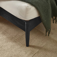 Bedstead corner with dark tapered legs and smooth frame edge