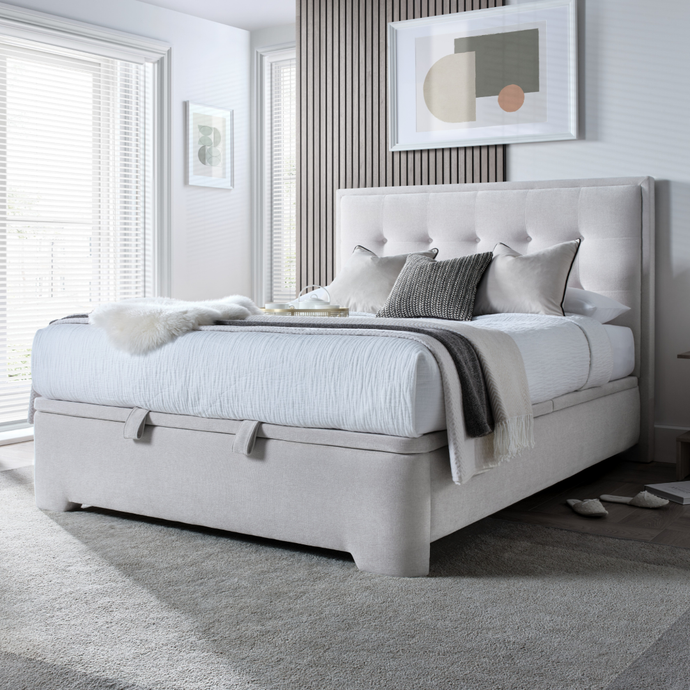 Upholstered ottoman storage bed in light gray fabric with tufted headboard and side rails