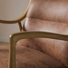 Vintage tan leather armchair close-up of armrest and wooden frame
