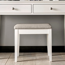 White wooden stool with upholstered light gray seat and rectangular legs