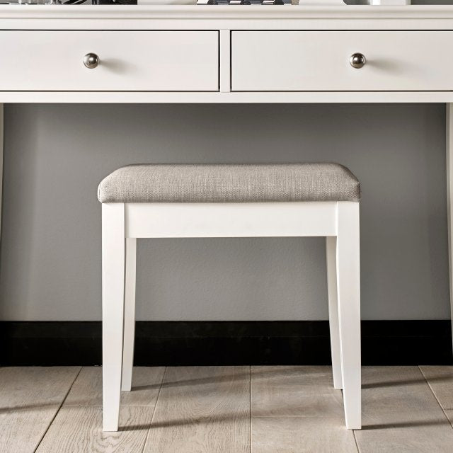 White wooden stool with upholstered light gray seat and rectangular legs