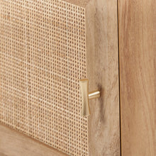 Woven rattan door with brass-tone handle on a light wood bedside table