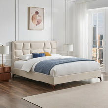 Natural upholstered bedstead with segmented headboard and white bedding with blue blanket