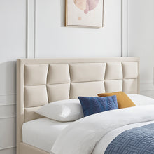 Natural upholstered bedstead with segmented headboard and white pillows with blue and gold accent