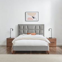 Silver-grey upholstered bedstead with segmented headboard and white bedding