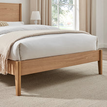 Wooden bedframe with slatted base and low side rails; mattress and bedding visible