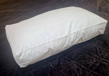 White fibre pillow with square edges, lying on a dark bedspread