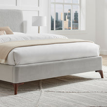 Grey upholstered bed frame with low skirt and dark wooden feet
