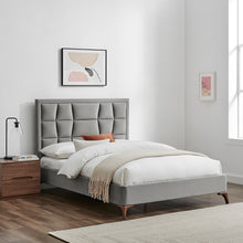 Silver-grey upholstered bedstead with segmented headboard and white duvet with beige throw