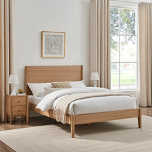 Wooden bedframe with low headboard, tapered legs, and slatted base; shown with bedding
