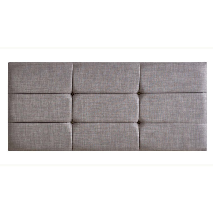 Upholstered panel headboard in light grey fabric with quilted square grid design