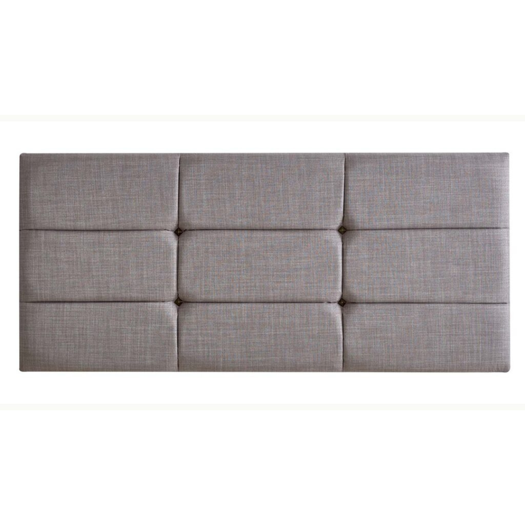Upholstered panel headboard in light grey fabric with quilted square grid design