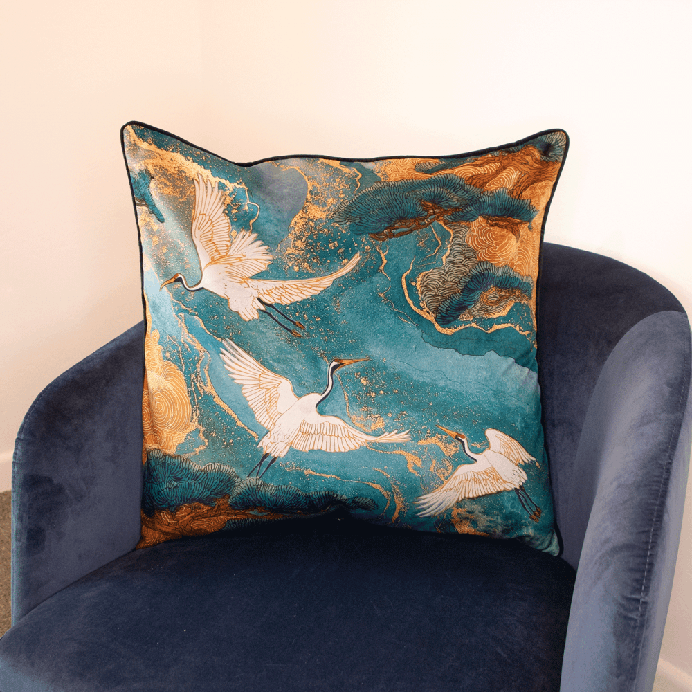 Teal bird motif cushion with crane silhouettes and gold swirls, square cover.