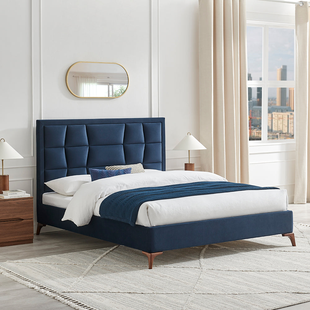 Navy upholstered bedstead with tall segmented headboard and low footboard